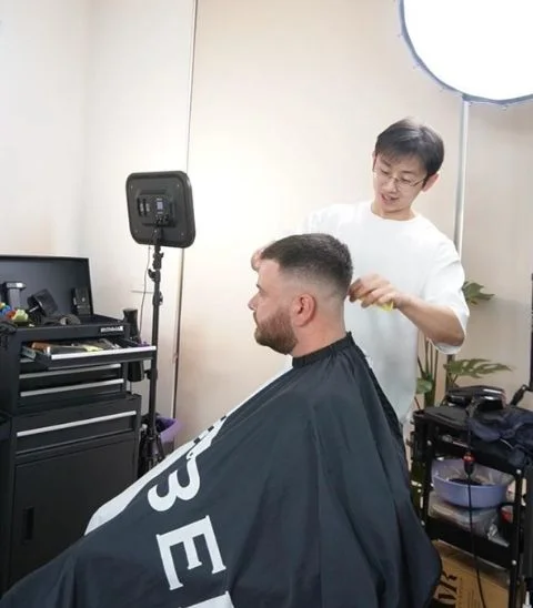 Barber focused while cutting hair with attention to detail