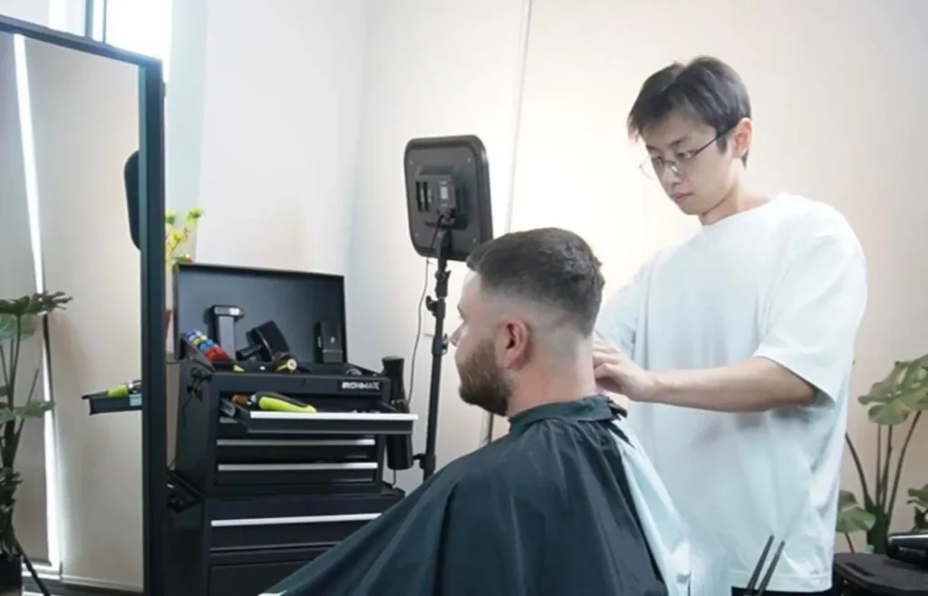 Home Pat standing in his barber studio in Springvale, ready to work